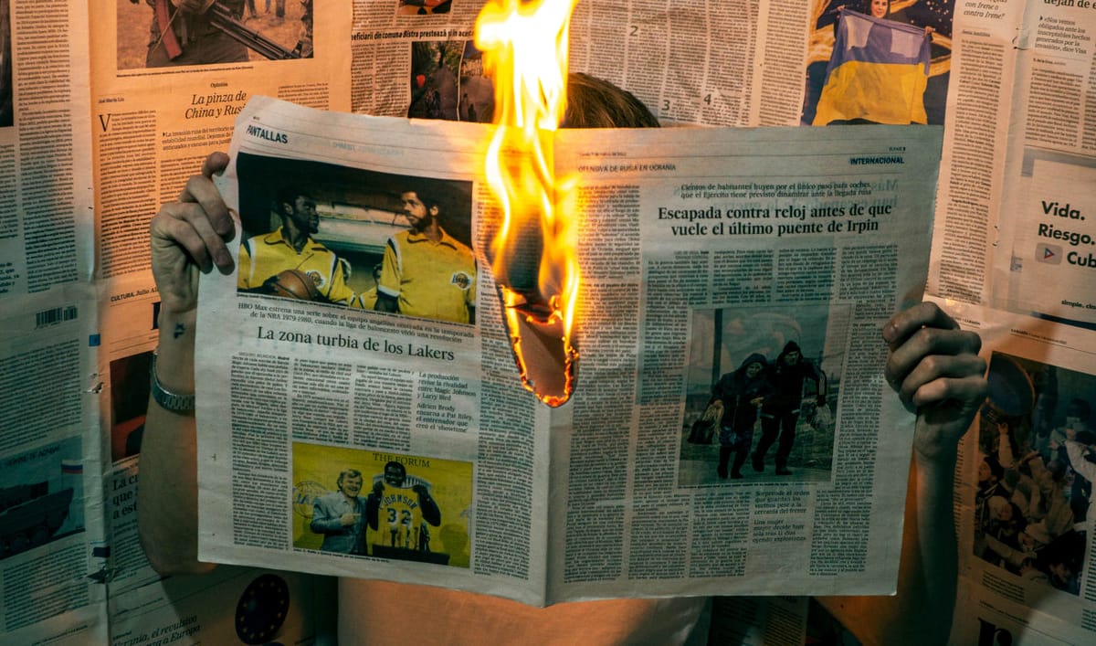 Person reading burning newspaper